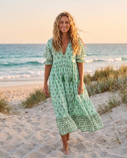 Woman wearing the Juno Floral V-Neck Maxi Dress in mint green on an Australian beach at golden hour