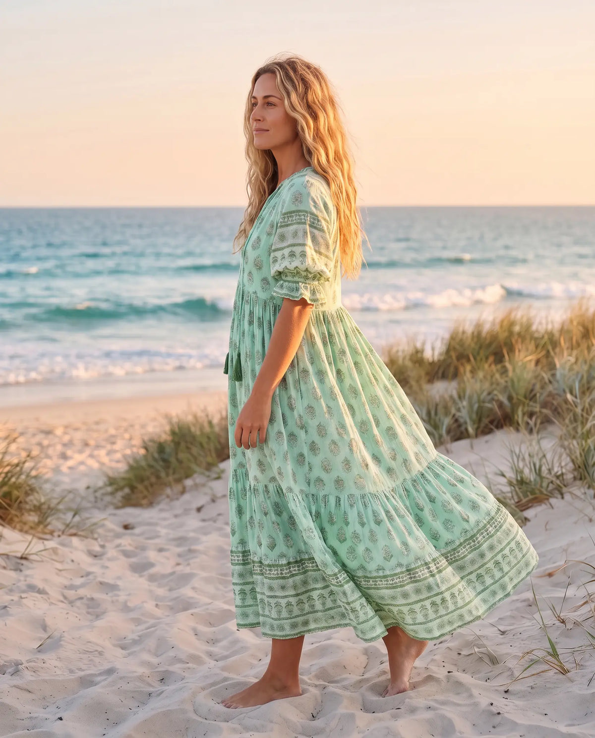 Side view of the Juno Floral V-Neck Maxi Dress in mint green on an Australian beach at golden hour