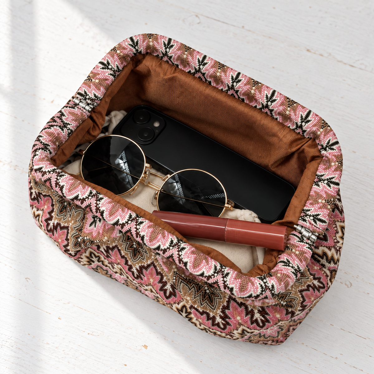 Juno Jacquard Pleated Clutch – open overhead view with phone, sunglasses, lip gloss and pouch on a white table