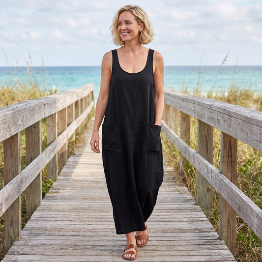 Matilda black U-neck sleeveless maxi dress worn by a blonde model on a beach boardwalk