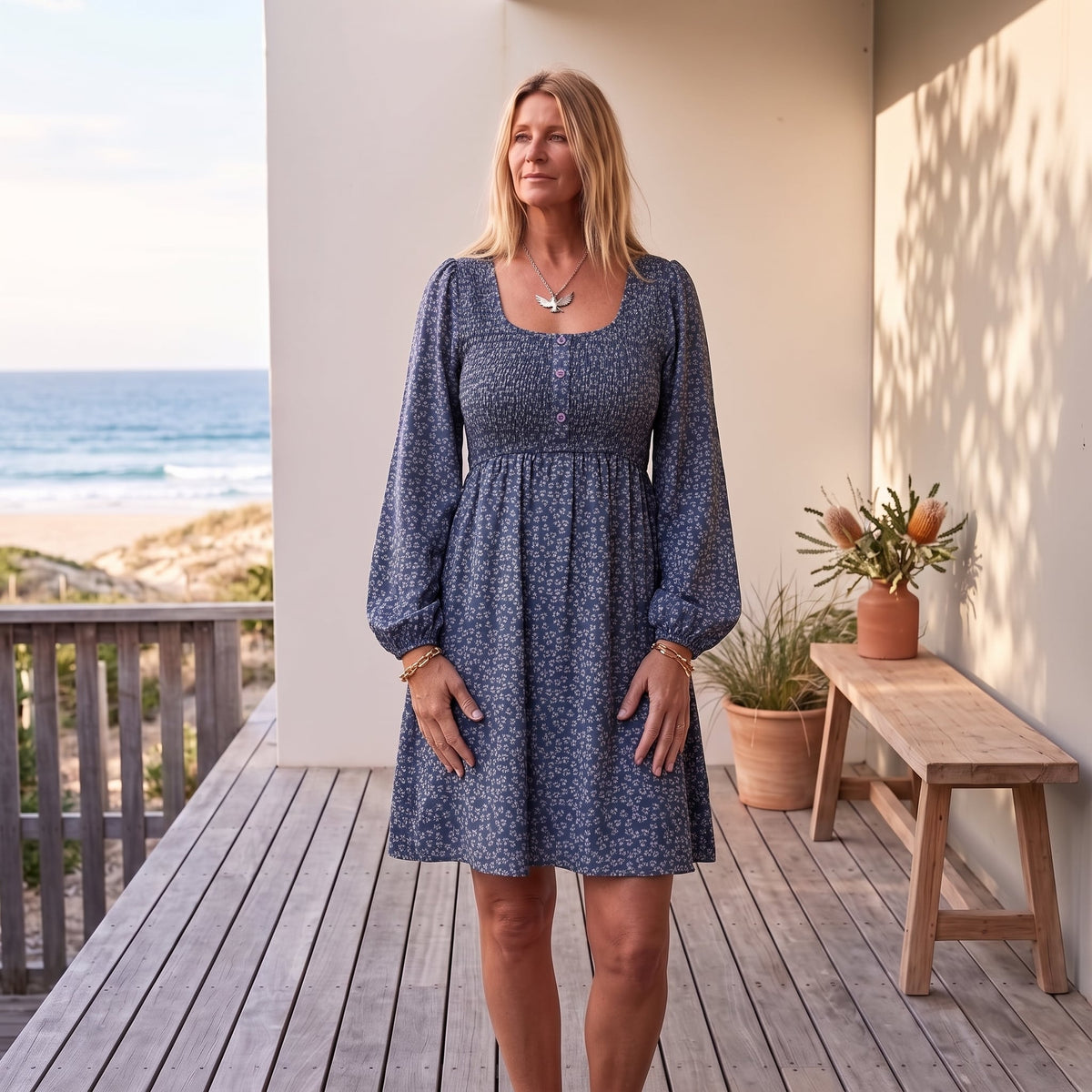 Penny | Women's Smocked Square Neck Puff Sleeve A-Line Mini Dress – Blue worn on an Australian coastal verandah